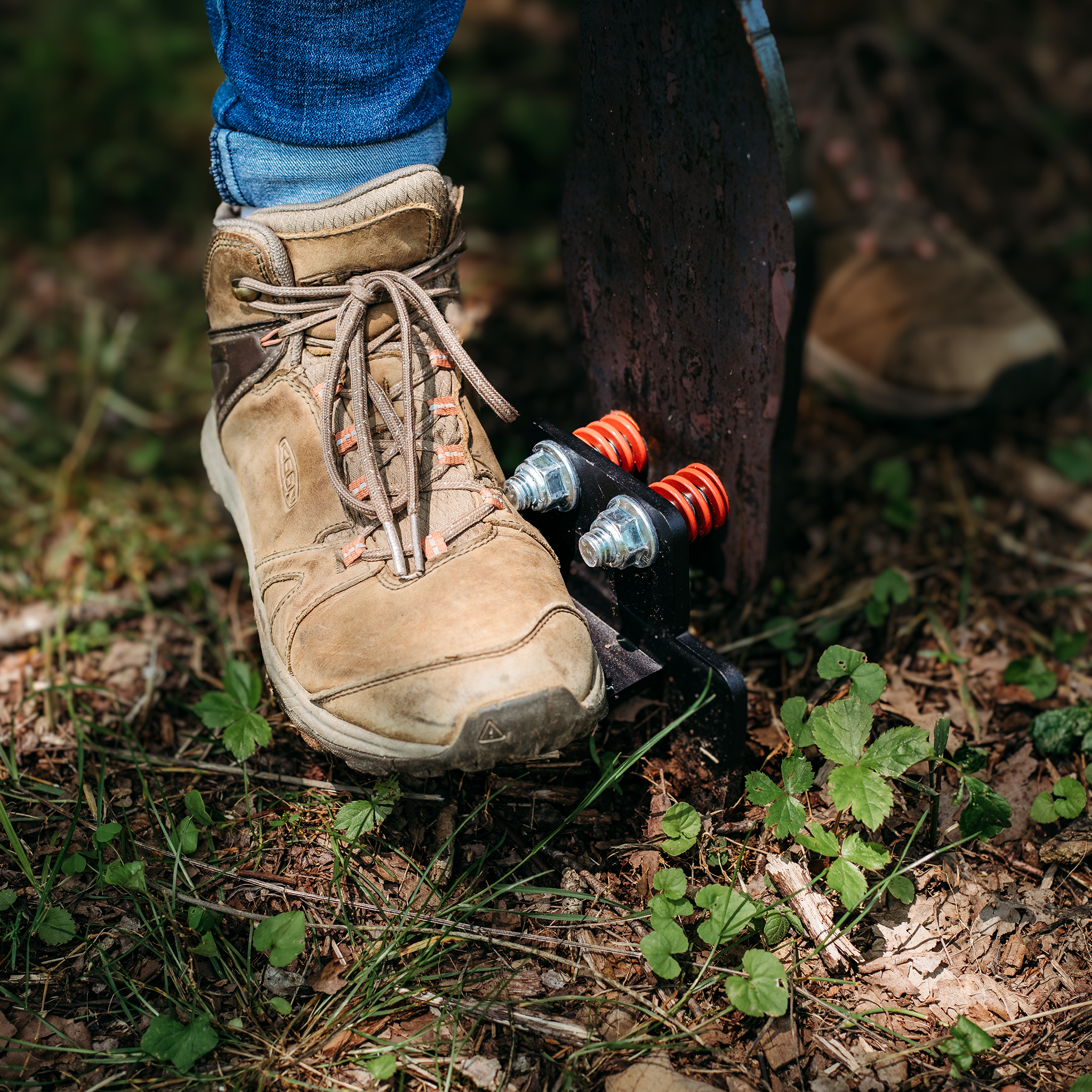 Boot stomping the ground spike popper target stand into the ground