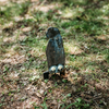 Raw prairie dog-shaped steel target  that has been shot mounted on ground stake stomped into the grass