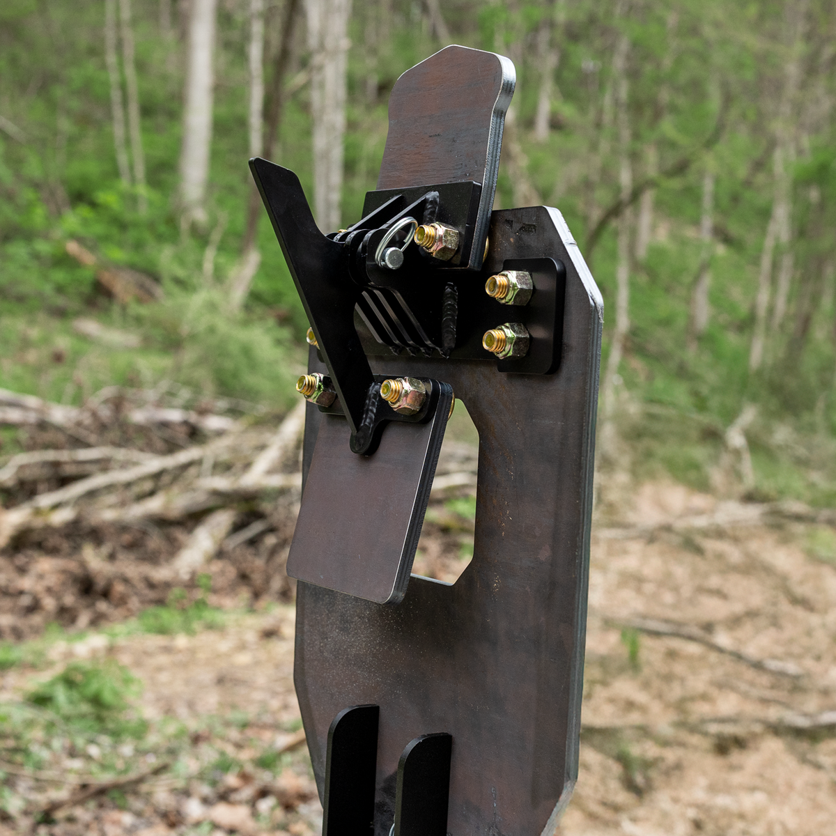 backside view of ar500 vital strike reactive target mounted on a 2x4 showing the head in the up position, hit the head & it will fall back flat against the black arm that is attached to the chest paddle