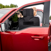 Man holding and standing behind his CaliberX Core Level IIIA Ballistic Vehicle seat shield with his weapon drawn while standing behind his vehicle's open door