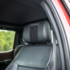 Black CaliberX Core Ballistic Vehicle seat shield elastic headrest strap installed onto a vehicle's headrest with velcro attachment