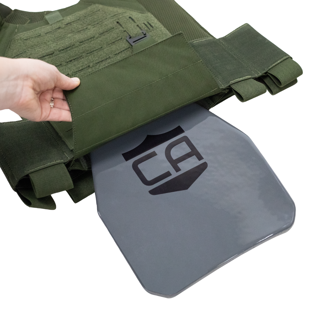 Green tactical vest with a gray steel hard armor plate being inserted into the bottom of the plate carrier, plate  features a CA logo on a white background