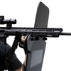 Close-up of a rifle being supported by a ballistic shield that has a ambidextrious weapon support bracket attached