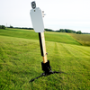 20 inch AR500 protector plate installed on 2x4 steel target stand upright at outdoor range