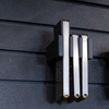 Black pistol magazine hanger showing three 45 cal magazines installed on the mount and hung on an Assault Wall tactical slat wall panel, 3 magazine capacity