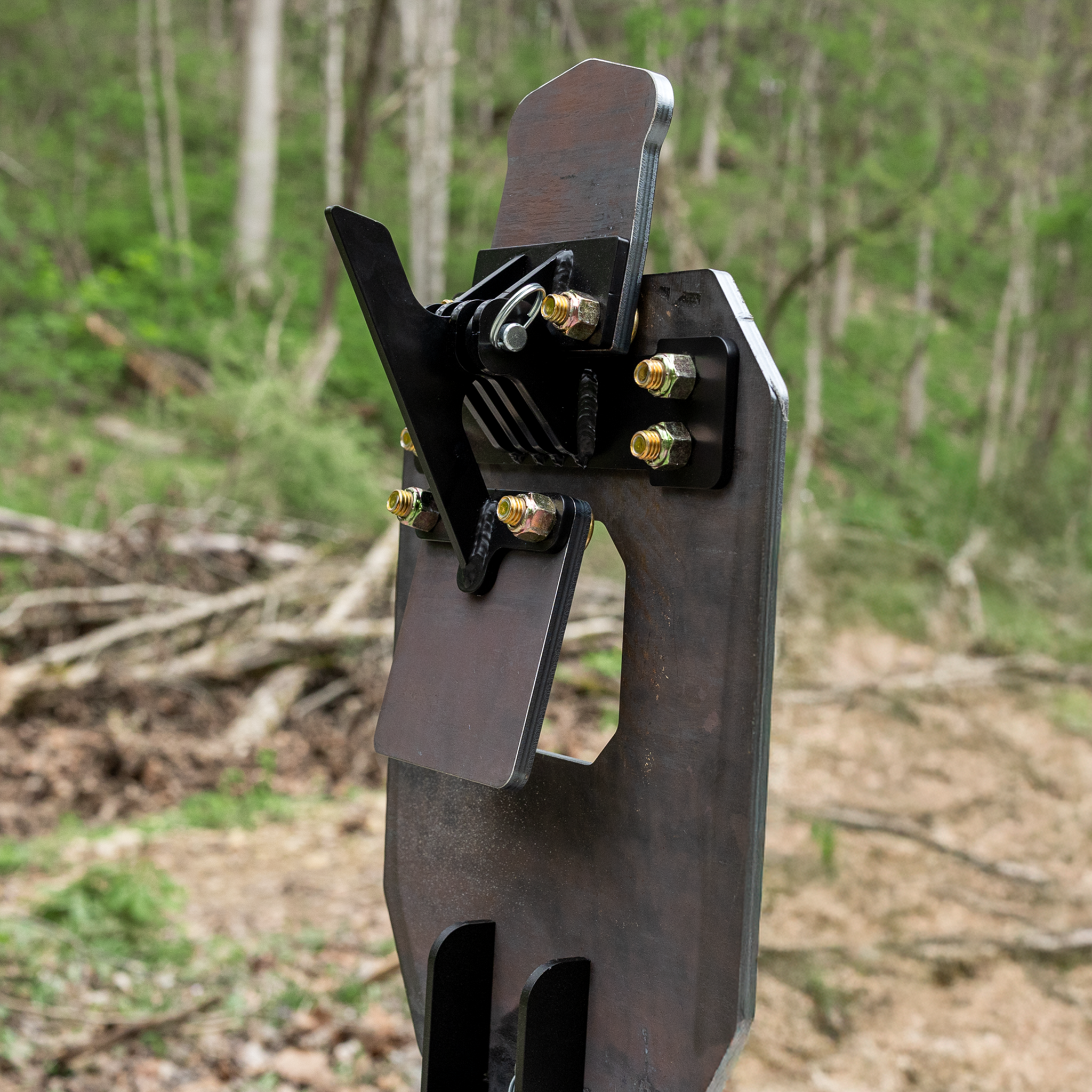 backside view of ar500 vital strike reactive target mounted on a 2x4 showing the head in the up position, hit the head  & it will fall back flat against the black arm that is attached to the chest paddle