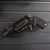 Black revolver barrel mounted on a carbon fiber rod, shown hanging from our Assault Wall tactical slat wall panel, black plastic mount with carbon fiber rod is universal and fits most pistols