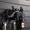 Close up of black plastic hanger for crossbows shown mounted to a black tactical gear slat wall named Assault Wall