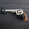 Large revolver pistol mounted on two hooks that have been set at varrying heights to properly support the barrel and grip of the gun, hooks are mounted on the Assault Wall slat wall panel system