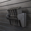 Assault Wall Universal Mag Holder with doublet tap logo with adjustable tension, shown loaded with PMAG rifle magazines mounted to a black Assault Wall panel, highlighting the adjustable slot options that the carbon fiber rod rests in