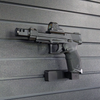 Assault Wall magazine mounted hanger for .22LR double stack pistols, Left facing mount with gun hanging from mag well on a black Assault Wall slat wall panel