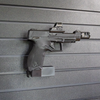 Assault Wall magazine mounted hanger for .22LR double stack pistols, Right facing mount with gun hanging from mag well on a black Assault Wall slat wall panel