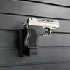 Assault Wall magazine mounted hanger for .22LR single stack pistols, Right facing mount with gun hanging from mag well on a black Assault Wall slat wall panel