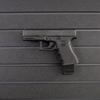 Left facing black plastic magazine mounted 9mm pistol hanger installed on Assault Wall Tactical slat wall