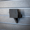Close-up of a black AK-47 rifle mount slid into position on our Assault Wall slat wall system