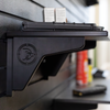 Close up of black plastic shelf support that branded lwith a Double Tap logo also showing the shelf profile, both are mounted to our black slat wall blurred in the background