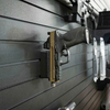 Assault Wall Magnetic gun mount shown with pistol mounted vertically by built in magnets, mount has been slid into position on a black Assault Wall slat panel