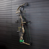 full view of black plastic hook hanger for compound bow shown mounted to a black tactical gear slat wall named Assault Wall with a cammo bow hung from the upper limb of the bow