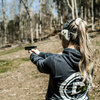 Double Tap Industries bluetooth noise canceling noise enhancement over the ear headphones for hearing protection at the shooting range on female model at the range
