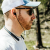Shooter wearing double tap industries Bluetooth hearing protection earbuds at outdoor range