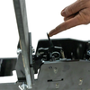 Close-up of a black metal fall popper base showing a finger compressing the spring by pushing down and towards the target, represents how to latch the target upright for forward falling operation on a white background.