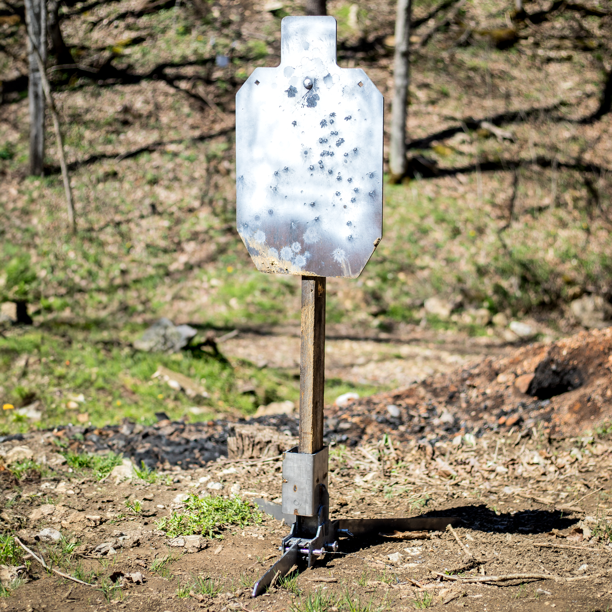 Steel target mounted on adjustable 2x4 shooting base at outdoor range