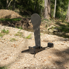 Angled view of AR500 fall popper with base and rubber bumper for forward or rear falling with a 33 inch classic ipsc popper target in wooded surroundings