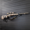 Camo muzzle loader with scope mounted on two hooks that have been set at varying heights to properly support the barrel and butt stock of the gun, hooks are mounted on the Assault Wall slat wall panel system