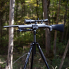 top view of stronghold lite black aluminum shooting tripod with rifle mounted on saddle clamp at outdoor shooting range