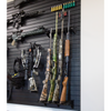 Black plastic vertical four gun storage mount, both upper & lower portion of mount shown mounted to our black  Assault Wall slat wall paneling loaded with shotguns & muzzelloaders with other tactical gear and guns shown mounted surrounding the mount
